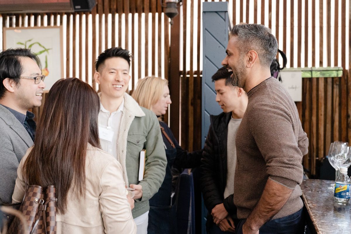 Ramit talking with a group of people at an IWT event